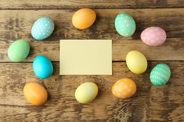 Easter eggs on wooden background with blank card