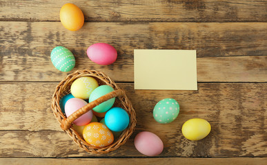 Easter eggs on wooden background with blank card