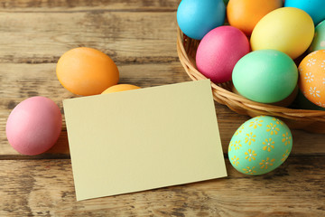 Easter eggs on wooden background with blank card