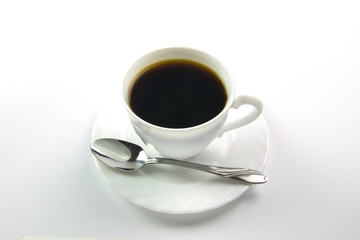 White cup of black coffee and a spoon on a white background
