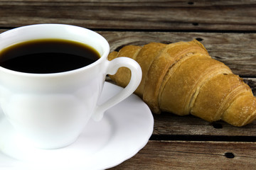 White cup of coffee and croissant