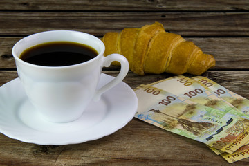 White cup of black coffee, croissant and rubles