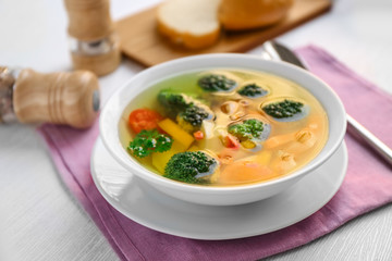 Bowl with vegetable soup on pink napkin