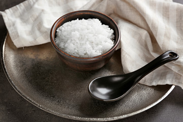 Fototapeta na wymiar White rice in bowl with spoon, closeup
