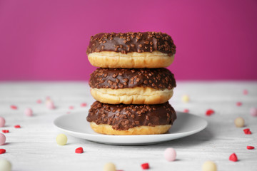 Stack of tasty glazed donuts on color background