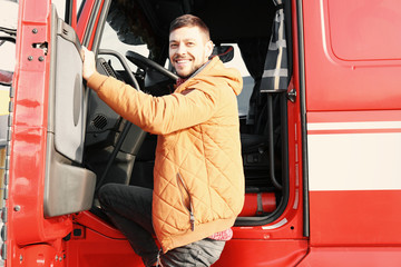 Handsome driver near big modern truck outdoors