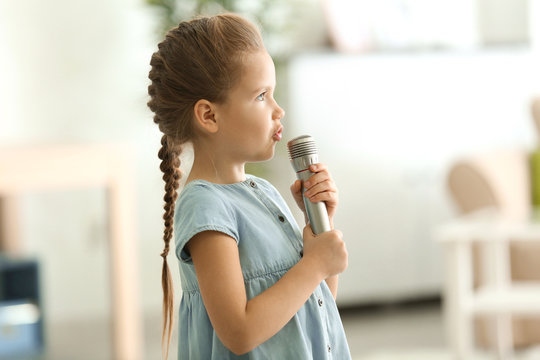 Cute little girl with microphone at home