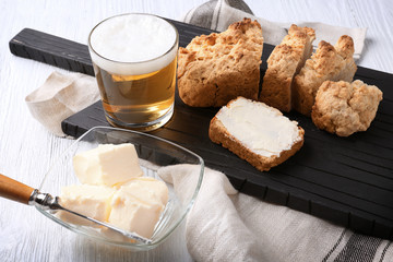 Wooden cutting board with sliced loaf of beer bread and butter