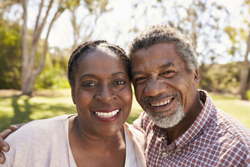 Outdoor Head And Shoulders Portrait Of Mature Couple In Park
