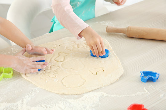 Little kids making biscuits on table