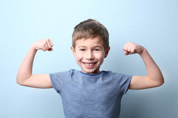 Portrait of little boy on light blue background