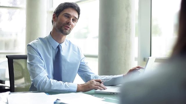 Businessman advising client in office