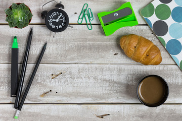 Knolling concept workspace background. Copy space available. Coffeei croissant, cactus, pencil on rustic, damaged wooden table.