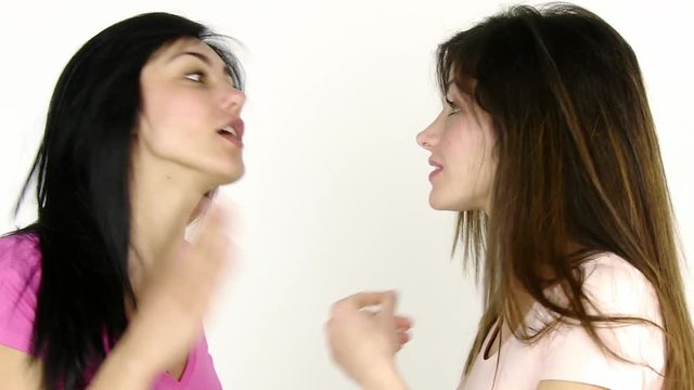 Two female friends fighting pushing hitting each other isolated