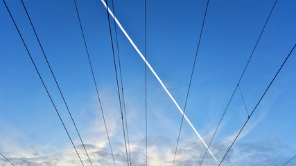 Symmetrical pattern of electrical wires on the blue sky background