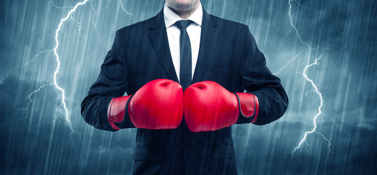 Businessman boxing in rain