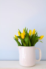 Yellow tulips in white jug