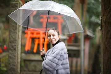Portrait of a woman under an umbrella in the territory of a Shinto temple