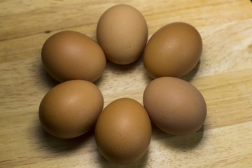 half-dozen eggs on a wooden plank