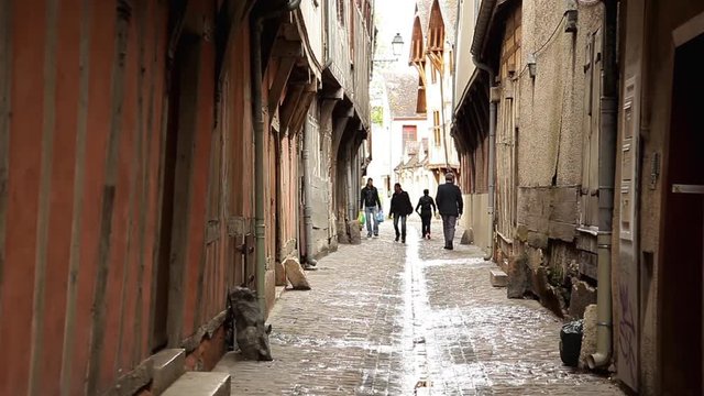 Pedestrians walking in narrow alleyway, Troyes, France