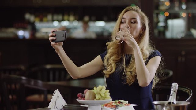 cute girl taking a selfie in a pompous cafe
