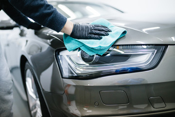 A man cleaning car with microfiber cloth, car detailing (or valeting) concept. Selective focus.  - obrazy, fototapety, plakaty