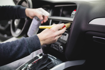 A man cleaning car interior, car detailing (or valeting) concept. Selective focus. 