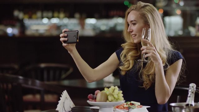 charming cute woman taking a selfie in a pompous restaurant