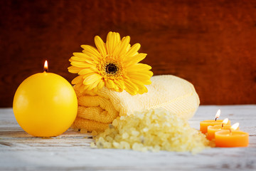 Obraz na płótnie Canvas Spa yellow products setting. Sea salt ,towel and candles on dark wooden background