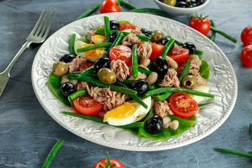 Fresh Tuna Green Bean salad with eggs, tomatoes, beans, olives on white plate. concept healthy food