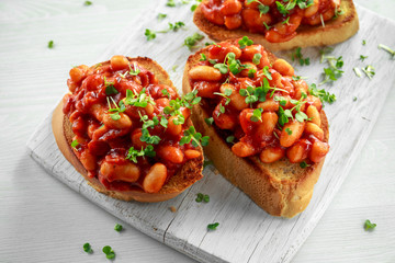Beans fried in tomato sauce on toasted bread with cross salad sprinkle