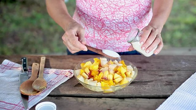 Adding suger to fruit salad mixture