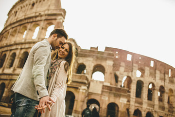 Fototapeta na wymiar Loving couple in front of the Colosseum in Rome