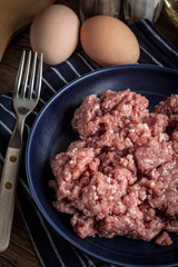 Minced meat on wooden background.