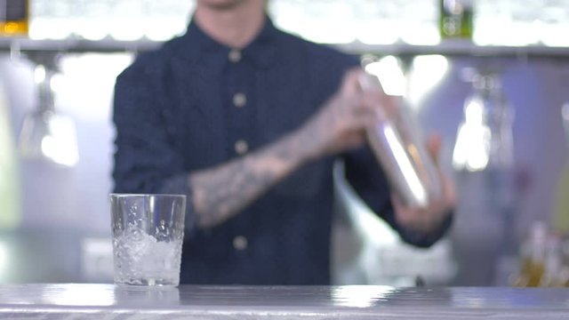 Close-up - the barman shaking a cocktail in the shaker on a bar