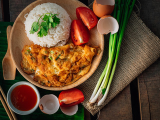 Vintage style Thai traditional food quick and common omelet with rice on top with wooden background wallpaper