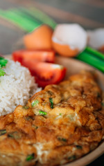 Vintage style Thai traditional food quick and common omelet with rice on top with wooden background wallpaper