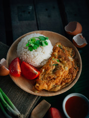 Vintage style Thai traditional food quick and common omelet with rice on top with wooden background wallpaper