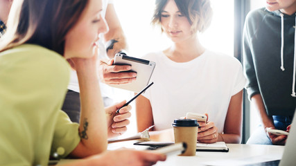 Group of young freelancers is discussing new business ideas during online meeting with the partners. Project leader is presenting new project to the team of designers by using a portable computer.