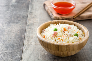 Fried chinese rice with vegetables on wooden background

