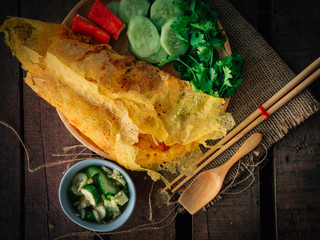 Vintage style Thai traditional food stuffed crispy egg crepe on top and wooden background wallpaper