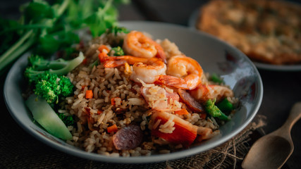 Vintage style Thai traditional food fried rice with shrimp on top and wooden background wallpaper