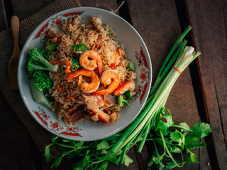 Vintage style Thai traditional food fried rice with shrimp on top and wooden background wallpaper