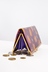 Inverted purse and coins are on the table. Gray background.