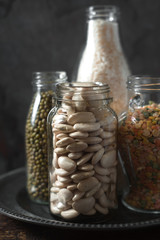 Lentils, white beans, rice in glass bottles