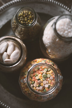Beans, lentils, rice in a glass jar on a plate