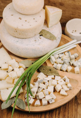 Different types of cheese on a wooden butcher