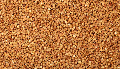 Dried brown buckwheat groats close up background