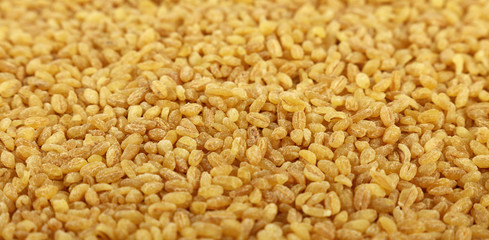 Yellow bulgur big grains close up background