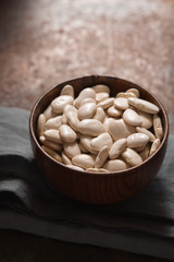 Large white beans in a wooden bowl side view